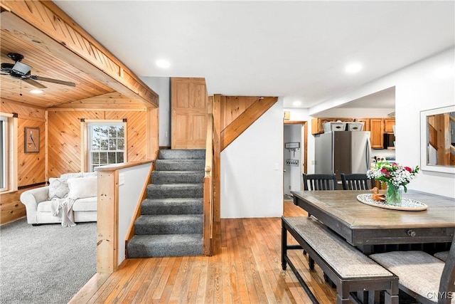 dining area with wooden walls, recessed lighting, light wood-type flooring, and stairs