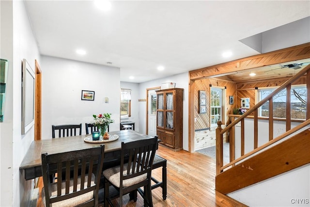 dining room featuring wooden walls, recessed lighting, stairs, and light wood-type flooring