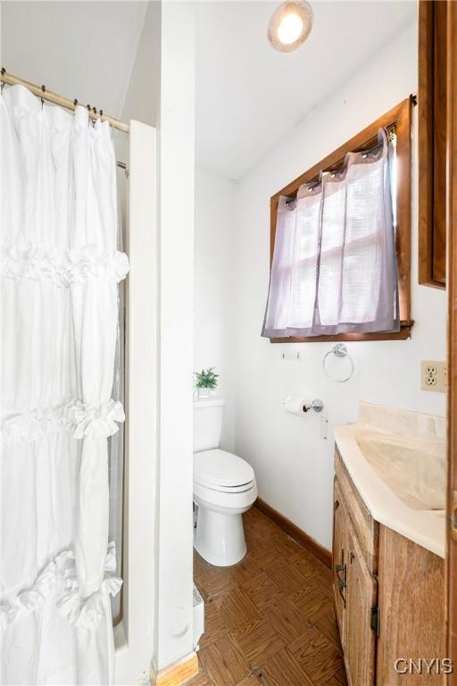 full bathroom featuring a shower with curtain, baseboards, toilet, and vanity