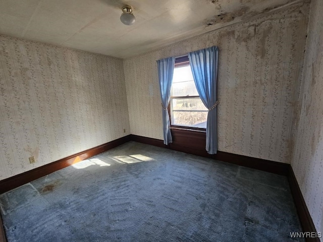 carpeted spare room with wallpapered walls and baseboards