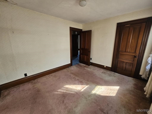 unfurnished bedroom featuring baseboards and carpet