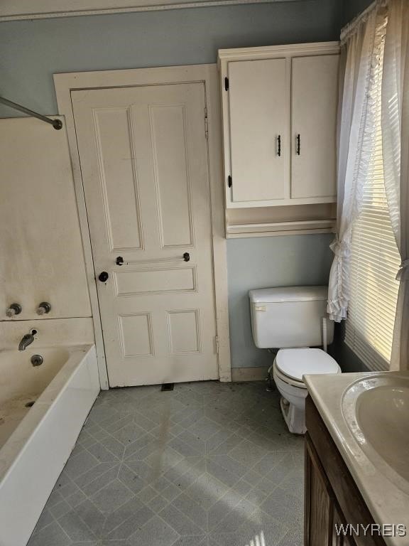 full bath with a wealth of natural light, toilet, and vanity