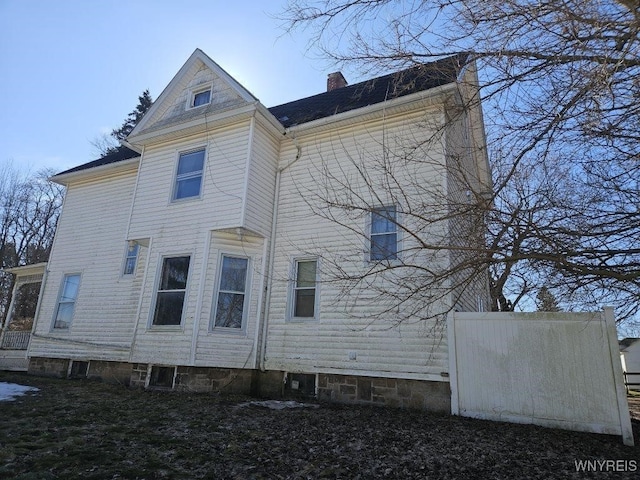 rear view of property featuring a chimney