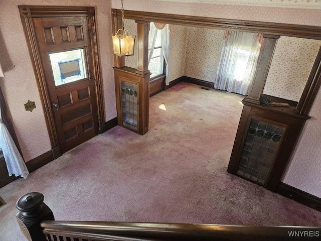 entryway with wallpapered walls, visible vents, light colored carpet, and baseboards