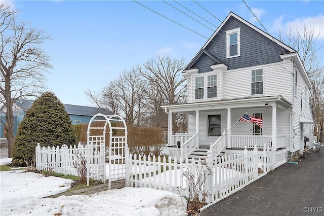 view of front facade featuring covered porch and fence