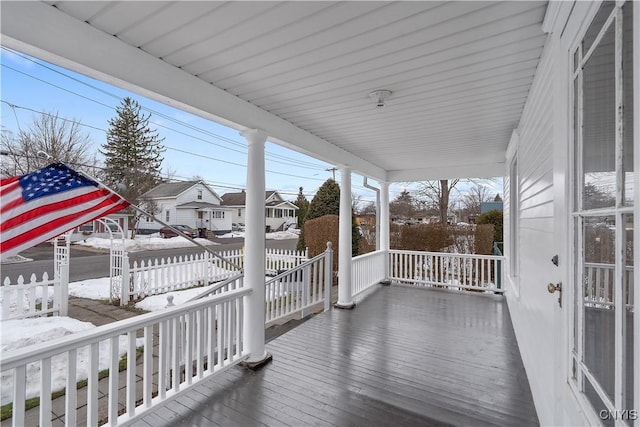 deck featuring a residential view, a porch, and fence