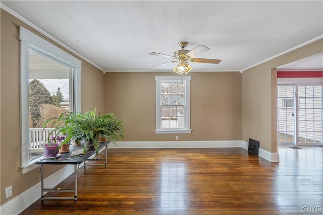 unfurnished room featuring plenty of natural light, ornamental molding, and hardwood / wood-style flooring