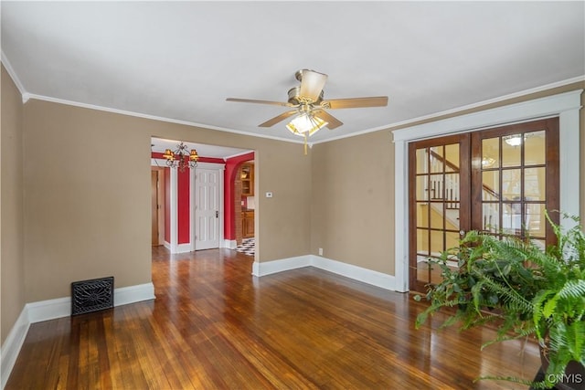 empty room featuring ornamental molding, ceiling fan with notable chandelier, french doors, wood-type flooring, and baseboards