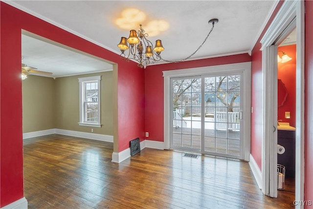 dining room with visible vents, baseboards, ornamental molding, ceiling fan with notable chandelier, and hardwood / wood-style flooring