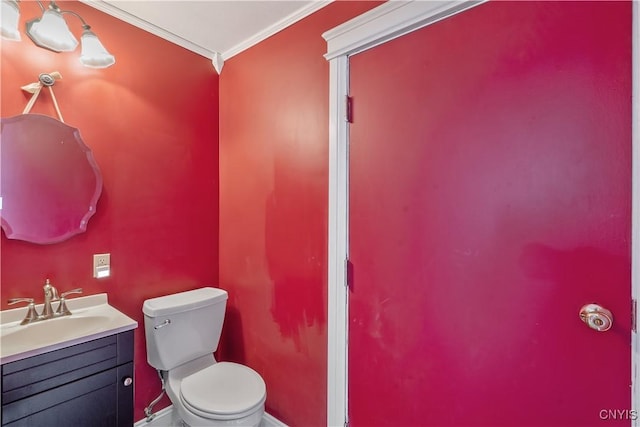 half bathroom with vanity, toilet, and ornamental molding