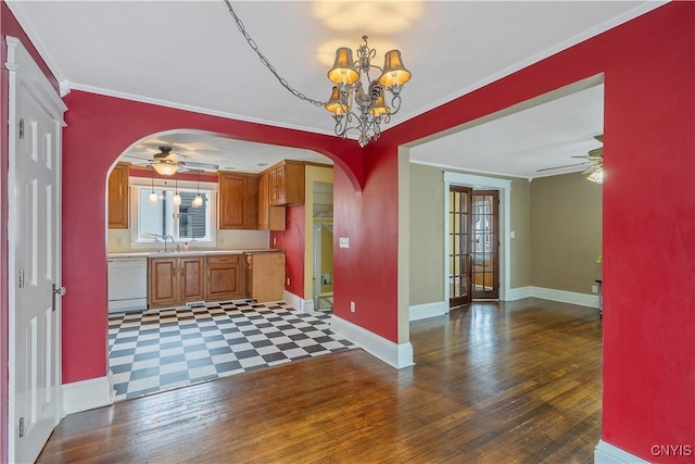 kitchen featuring arched walkways, dishwasher, brown cabinetry, and light countertops