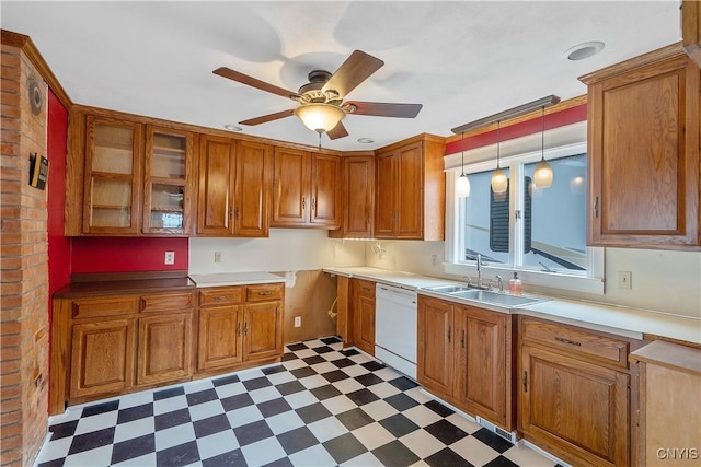 kitchen featuring a sink, brown cabinets, dishwasher, and dark floors