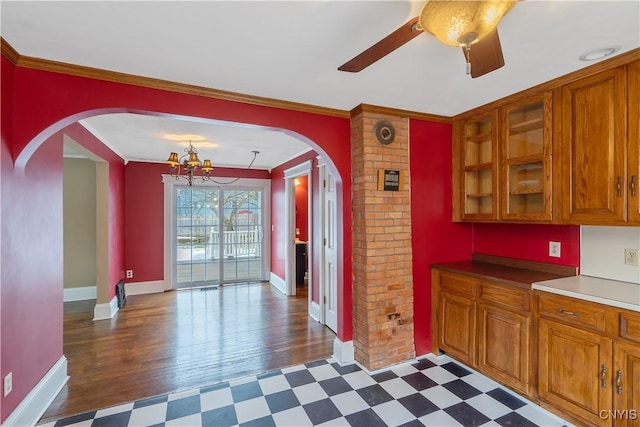 kitchen with brown cabinets, arched walkways, and dark floors