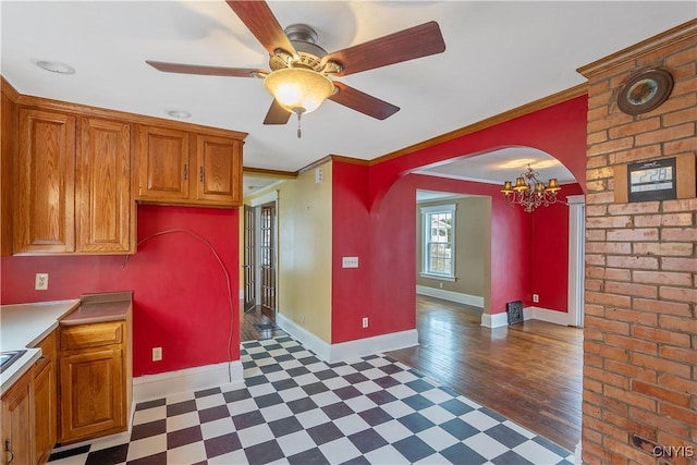 kitchen with crown molding, brown cabinetry, baseboards, and tile patterned floors