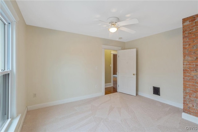 empty room with visible vents, baseboards, carpet, and ceiling fan