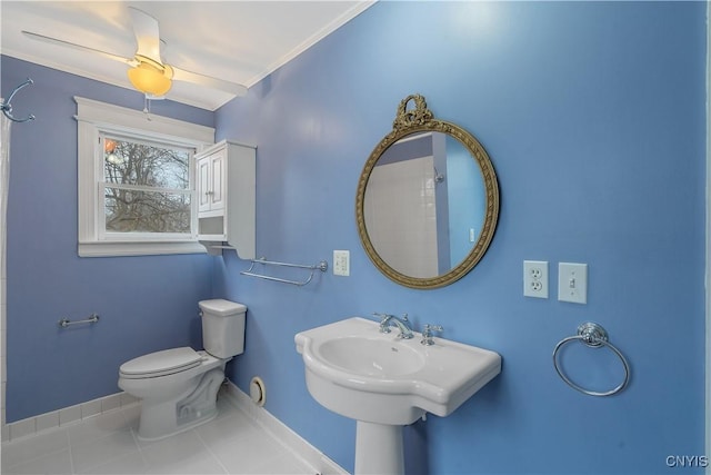 bathroom with tile patterned floors, toilet, crown molding, baseboards, and ceiling fan