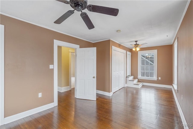 unfurnished bedroom with baseboards, wood finished floors, and crown molding