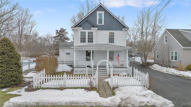 view of front of property featuring a fenced front yard and a porch