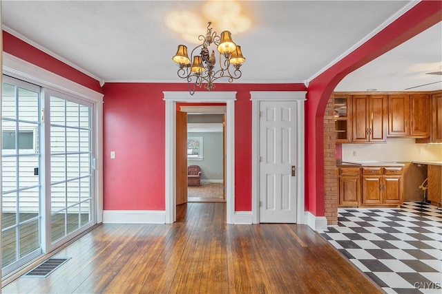 unfurnished dining area featuring an inviting chandelier, a healthy amount of sunlight, visible vents, and baseboards