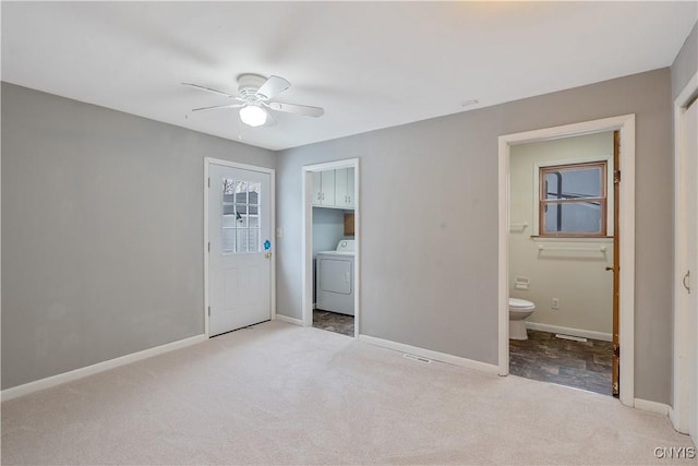 carpeted spare room featuring washer / clothes dryer, baseboards, and ceiling fan