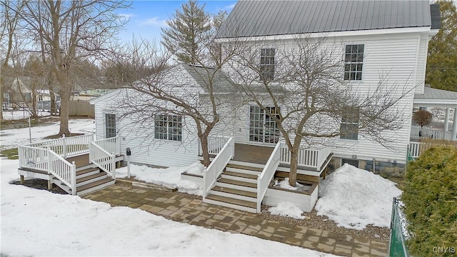 view of front of property featuring stairway, metal roof, and a deck