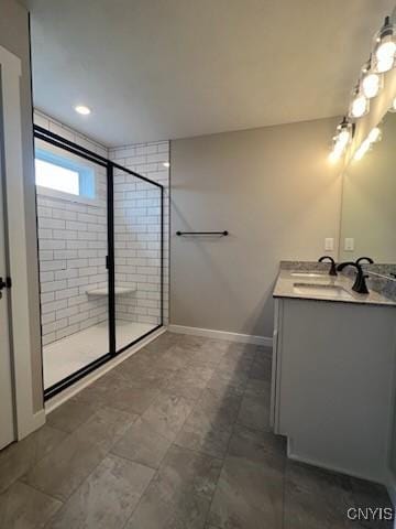 full bath with vanity, baseboards, and a stall shower