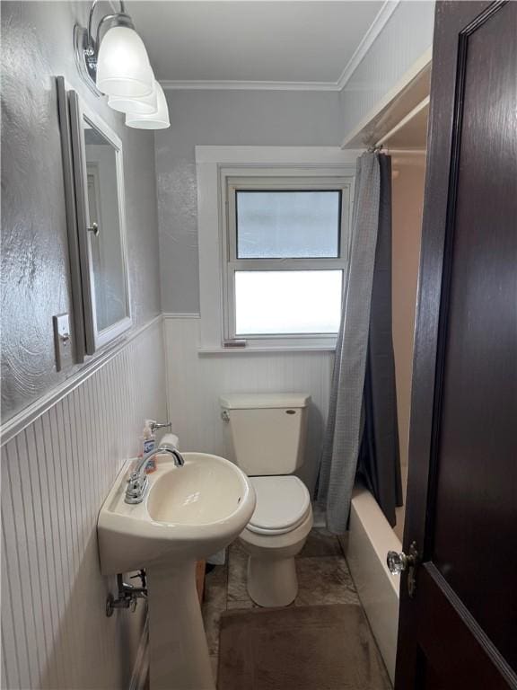 full bath featuring toilet, shower / bath combo, ornamental molding, wainscoting, and a sink