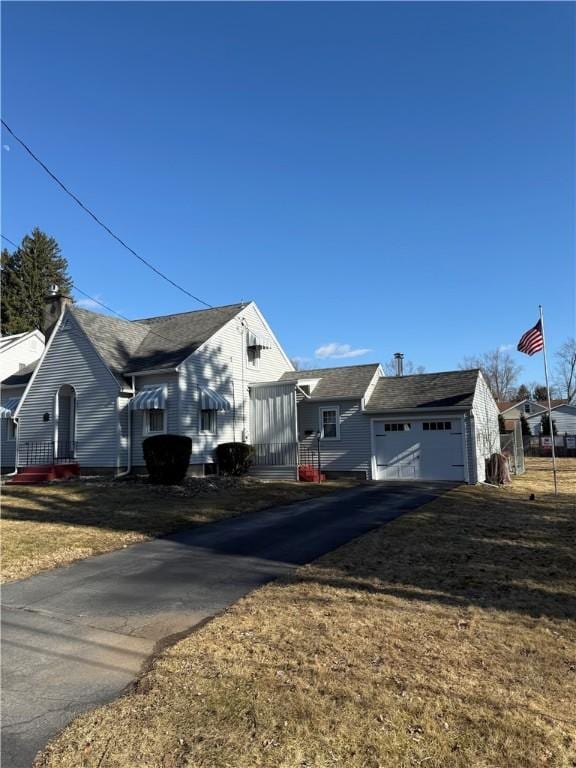 view of front of house with aphalt driveway and a front yard