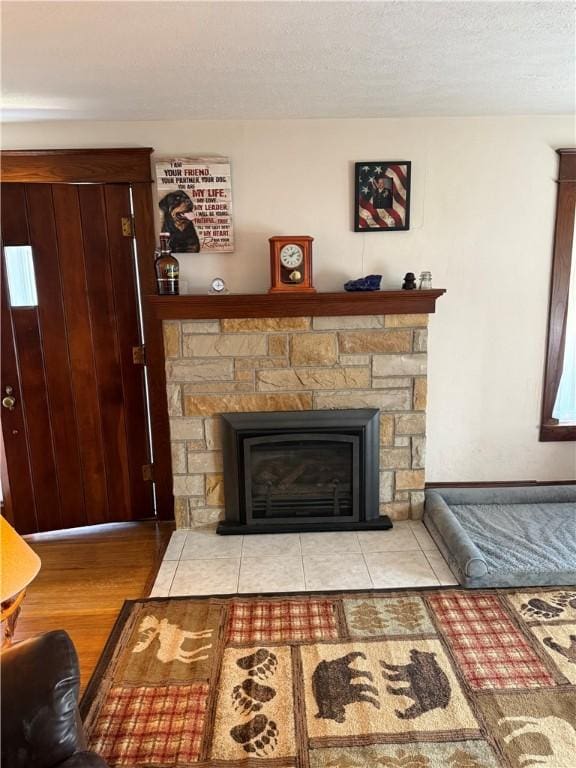 room details featuring a stone fireplace, wood finished floors, and a textured ceiling