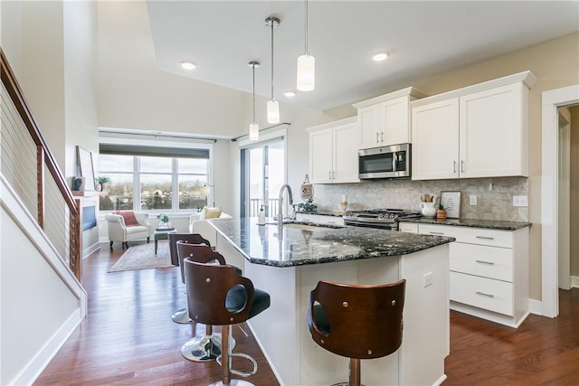 kitchen with a sink, decorative backsplash, appliances with stainless steel finishes, and a breakfast bar