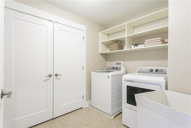 laundry room featuring laundry area, light floors, a sink, and separate washer and dryer