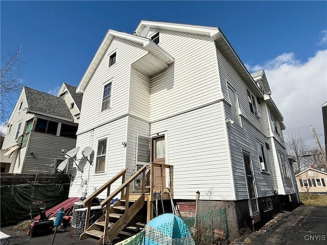 rear view of house featuring fence