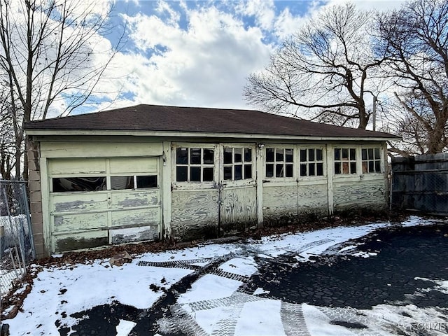 snow covered garage with fence