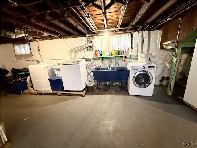 basement featuring washing machine and clothes dryer and a sink