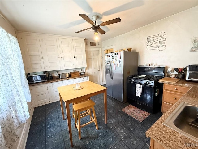 kitchen featuring white cabinetry, a ceiling fan, appliances with stainless steel finishes, and a sink