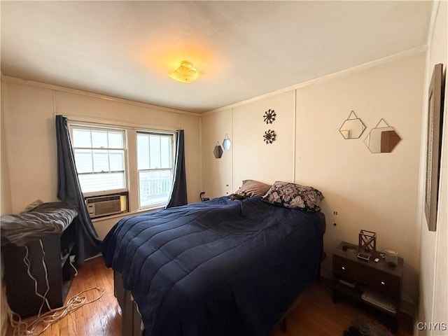 bedroom featuring cooling unit, wood finished floors, and crown molding