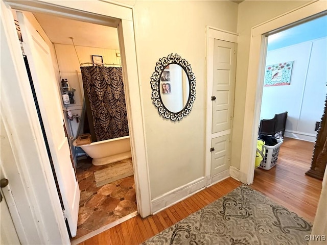 hall with wood finished floors and baseboards