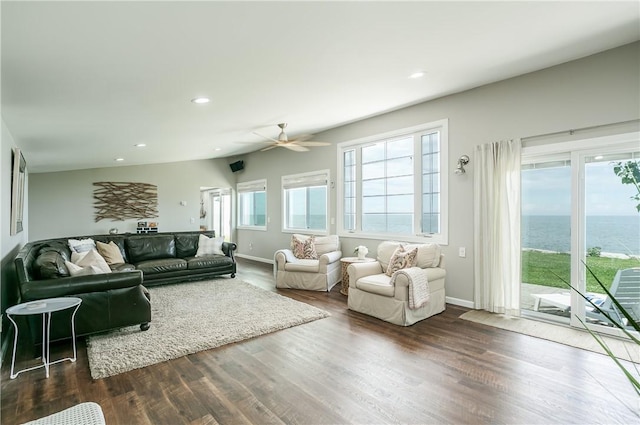 living room featuring recessed lighting, wood finished floors, baseboards, and a water view