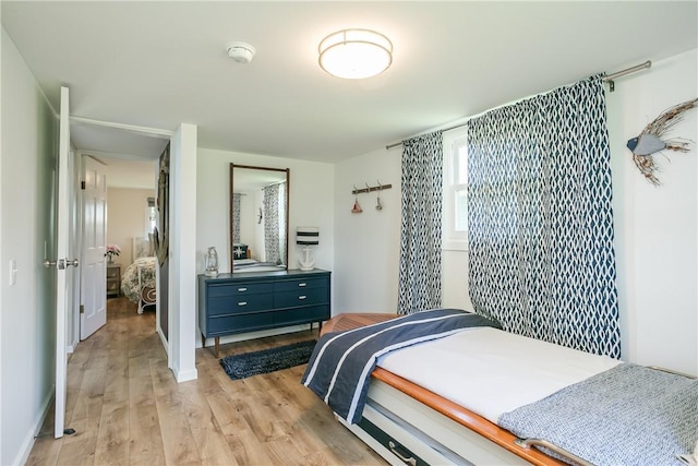 bedroom featuring baseboards and light wood finished floors