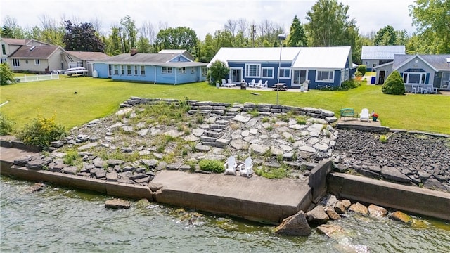 exterior space with a residential view, a lawn, and a water view