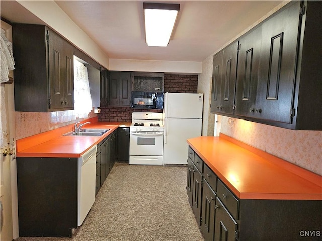 kitchen featuring dark cabinetry, white appliances, light floors, a sink, and light countertops