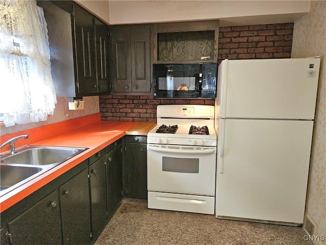 kitchen with a sink, white appliances, and brick wall