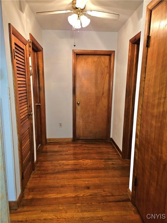 hallway featuring baseboards and wood finished floors