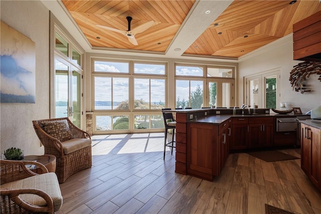 kitchen with dark countertops, dark wood-style floors, wooden ceiling, and a sink