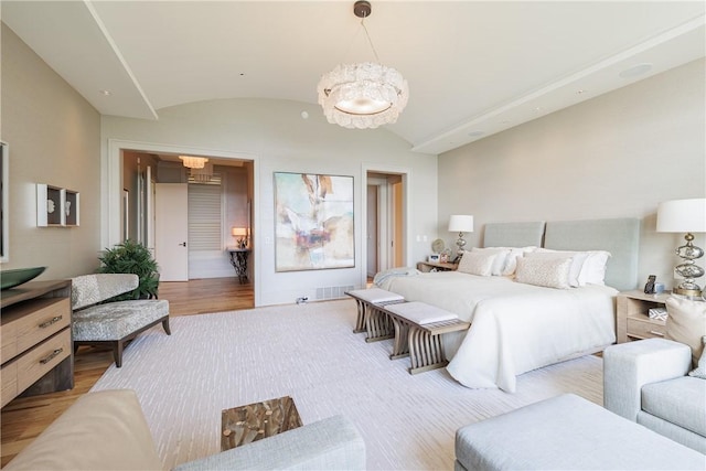 bedroom featuring light wood-style flooring and vaulted ceiling