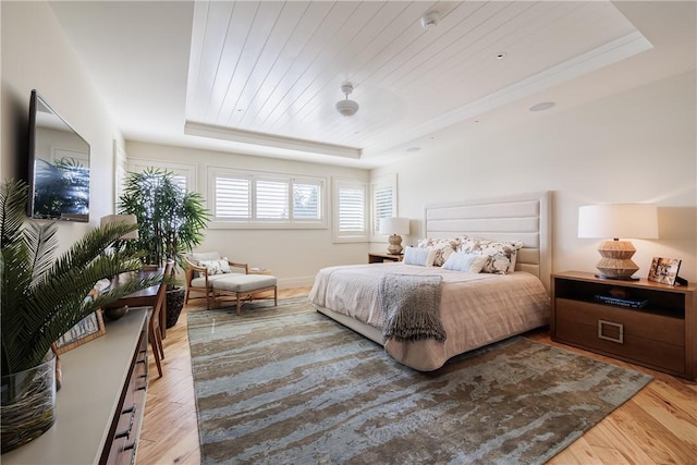 bedroom featuring a tray ceiling, wood finished floors, and wood ceiling