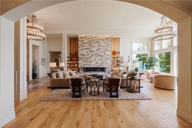 interior space with light wood finished floors, an inviting chandelier, and a towering ceiling