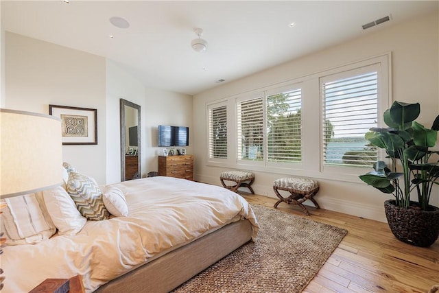 bedroom featuring wood finished floors, visible vents, and baseboards