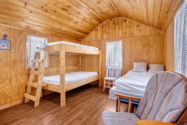 bedroom with lofted ceiling, wood finished floors, wood ceiling, and wood walls