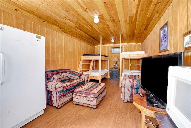 sitting room featuring wood ceiling, wooden walls, and wood finished floors